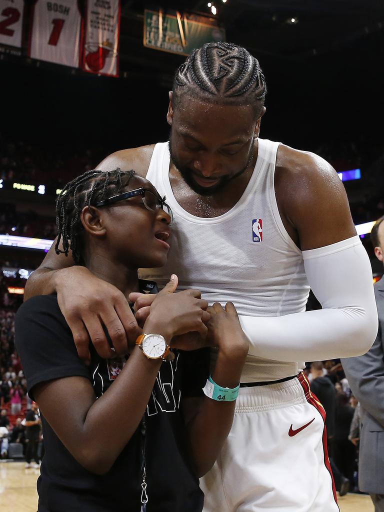 Dwyane hugs Zaya after his final NBA game in 2019. (Photo by Michael Reaves/Getty Images)