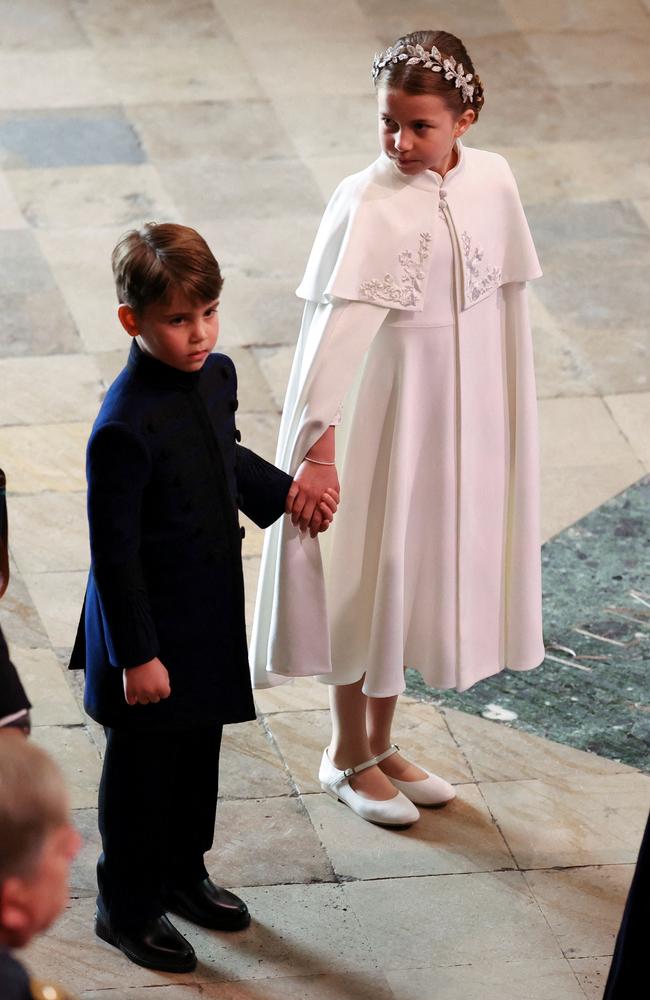 Prince Louis and Princess Charlotte hold hands as they prepare to enter Westminster Abbey. Picture: AFP