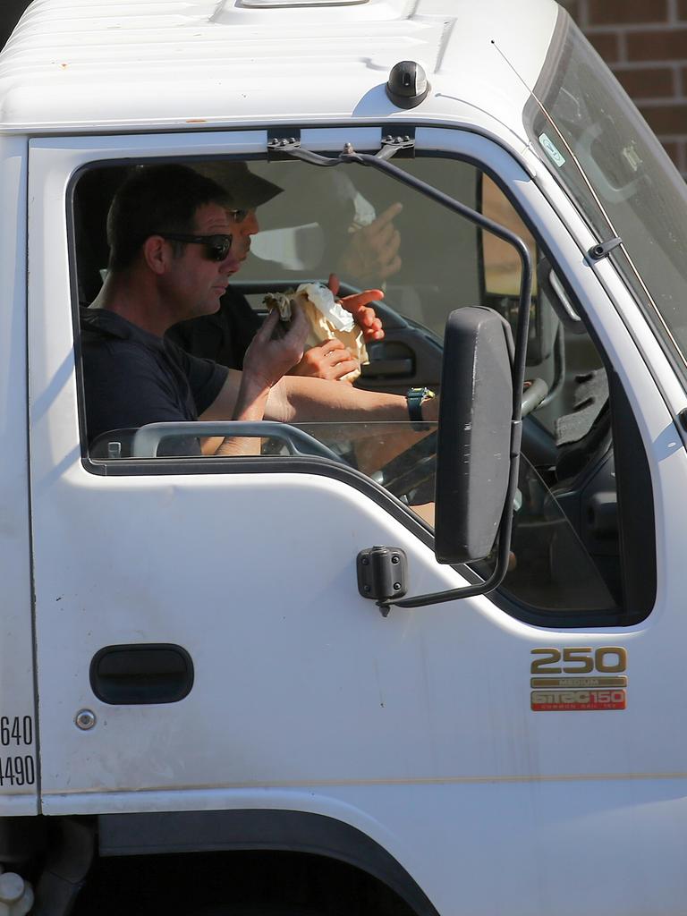 A driver eats on South Dowling St. Picture: John Grainger