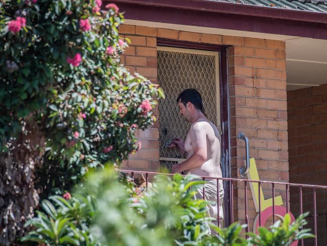 A shirtless man passes money through the cut-out hole in the door last month. Picture: Jason Edwards