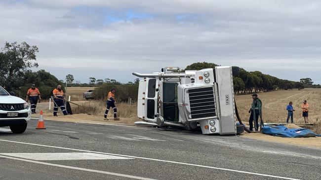 Crews working roadside to right the rolled vehicle. Picture: Isaac Selby