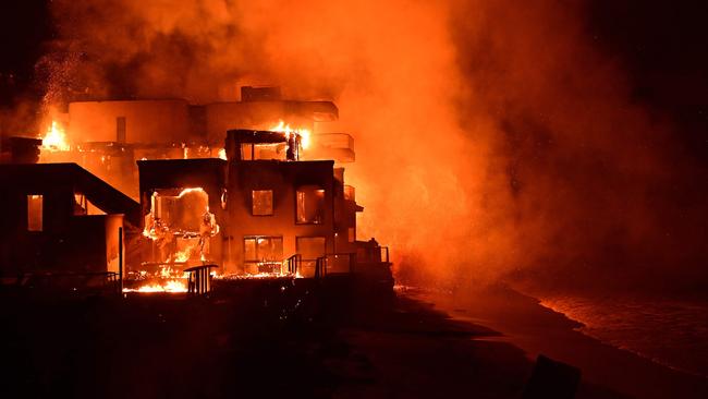 A beach house is engulfed in flames as the Palisades Fire burns along Pacific Coast Highway in Malibu, California. Photo by AGUSTIN PAULLIER / AFP