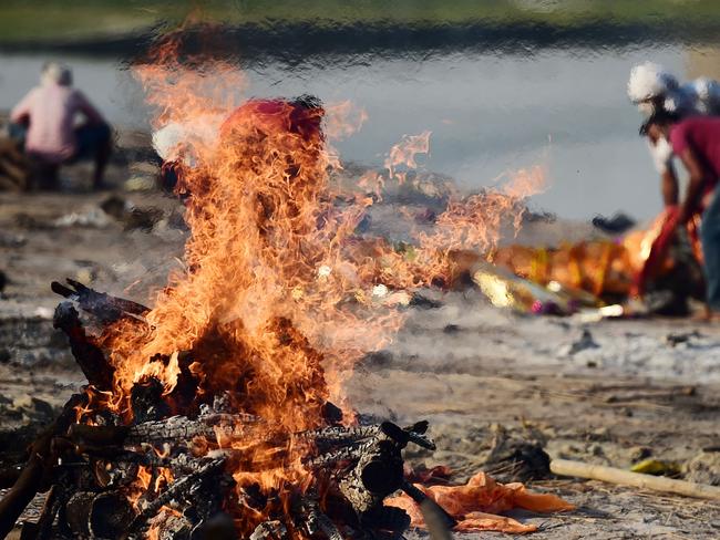 Family members and relatives are seen around the burning pyres of victims who lost their lives due to the coronavirus at Daraganj Ghat near Sangam. Picture: AFP