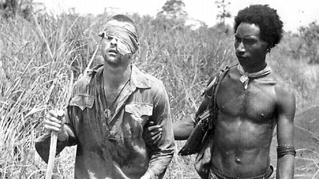 New Guinean villager Raphael Oimbari who became famous during WWII as one of the fuzzy wuzzy angels, leads wounded soldier to safety. Australian Armed Forces / Army / New Guinea / Wuzzies PNG Private George 'Dick' Whittington (L)