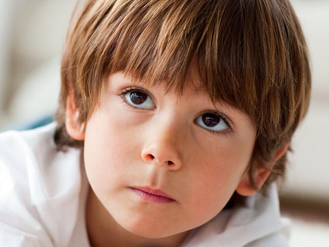 Concentrated little boy watching TV lying on the floor