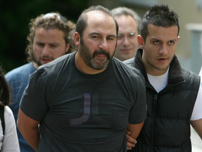 Tony Mokbel is escorted away after appearing in court in Athens in 2007.