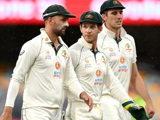 BRISBANE, AUSTRALIA - JANUARY 18: Tim Paine, Nathan Lyon and Pat Cummins of Australia are seen leaving the field as a rain delay is called during day four of the 4th Test Match in the series between Australia and India at The Gabba on January 18, 2021 in Brisbane, Australia. (Photo by Bradley Kanaris/Getty Images)