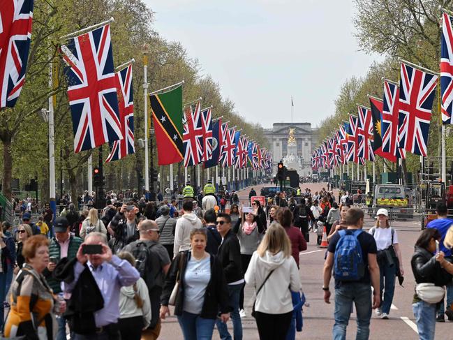 People walk beneath flags of the Union and Commonwealth along The Mall, towards Buckingham Palace, in central London, ahead of the Coronation. Picture: AFP