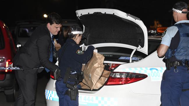 Police remove items of interest in evidence bags on Friday night. Picture: Gordon McComiskie