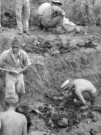 Under Australian supervision, Japanese prisoners exhume the bodies of Australian and Dutch soldiers killed in the Laha massacre in February 1942. Source: Australian War Memorial