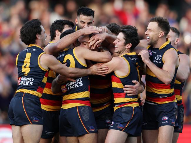 ADELAIDE, AUSTRALIA - JUNE 10: Taylor Walker of the Crows surrounded by teammates after a goal during the 2023 AFL Round 13 match between the Adelaide Crows and the West Coast Eagles at Adelaide Oval on June 10, 2023 in Adelaide, Australia. (Photo by Sarah Reed/AFL Photos via Getty Images)