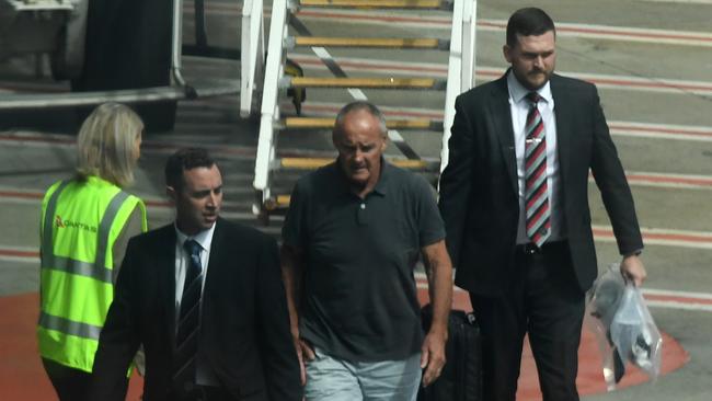 Chris Dawson, centre, is escorted by NSW Police detectives as he is extradited from the Gold Coast following his arrest in December 2018 for the murder of his wife, Lyn. Picture: AAP Image/Dean Lewins