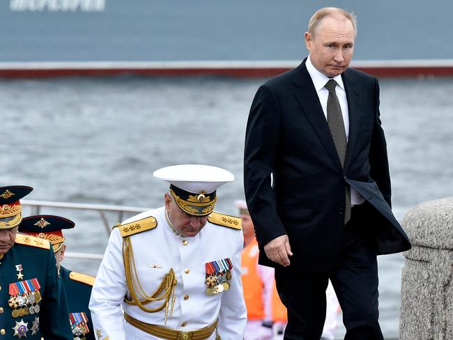 Russia's President Vladimir Putin (R) walks with Commander-in-Chief of the Russian navy, Admiral Nikolai Yevmenov (C) as he takes part in the main naval parade marking Russian navy Day. Picture: AFP