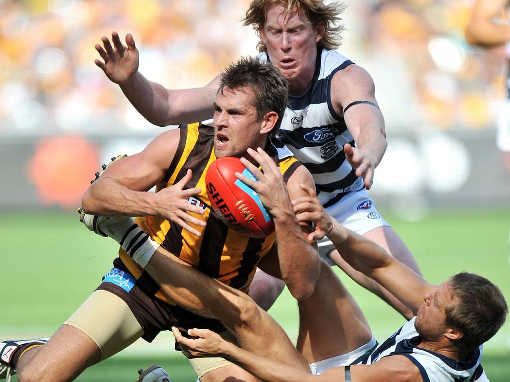 Luke Hodge is tackled by Cameron Ling and David Wojcinski in 2010.