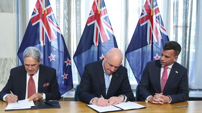 New Zealand First leader Winston Peters, incoming Prime Minister Christopher Luxon and ACT leader David Seymour sign the coalition agreement. Picture: Getty Images.