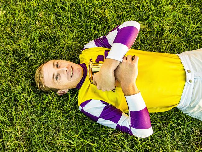 Jockey Ben Looker lies down on his home Grafton turf after winning the Grafton Cup on Sacred Day