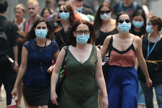 Pedestrians wearing face masks to protect from smoke haze as they cross a busy city street. Picture: Don Arnold/Getty Images