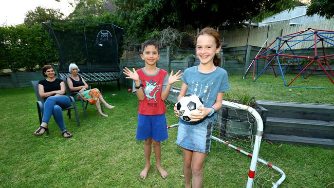 Twins Oliver and Alexis Taylor, 8, playing in their backyard, while watched by mum Naomi Dorland and grandmother Su Dorland. Picture AAP/David Clark