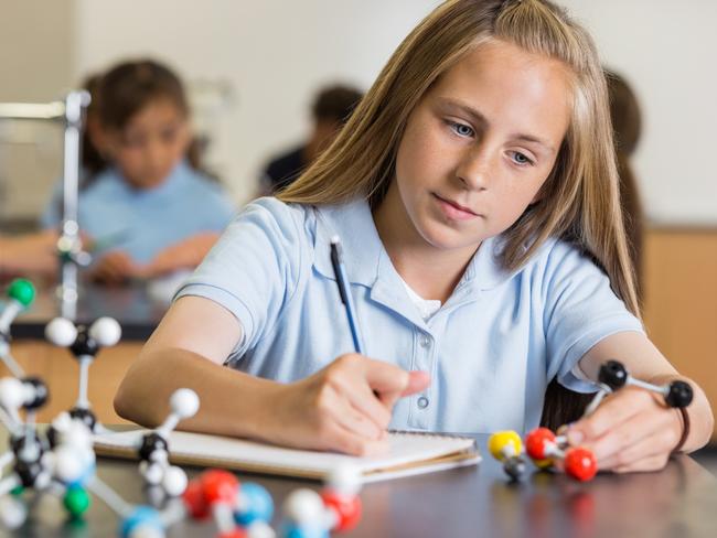 CAREERS: Preteen girl using atom educational toy in science class