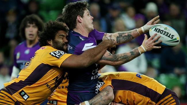 Ben Hampton gets a pass away as Sam Thaiday makes a tackle. Picture: Colleen Petch