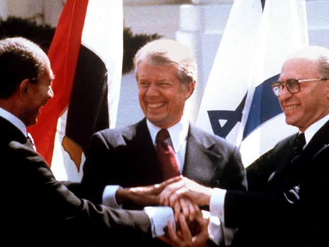 Egyptian President Anwar Sadat (L), US President Jimmy Carter (C) and Israeli Prime Minister Menachem Begin clasp hands on the north lawn of the White House in Washington, DC, 26/03/1979, as they completed signing of the peace treaty between Egypt and Israel.