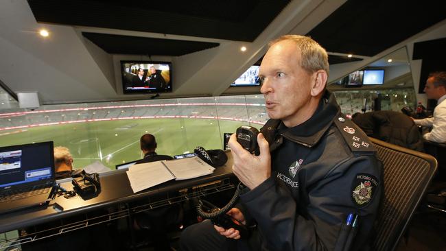 Commander Tim Hansen relays information to the officers on the ground in the Crowd Management Observation Room. Picture: David Caird