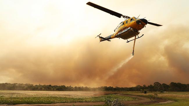 A water-bombing helicopter prepares to dump on a fire raging at Deepwater. Picture: Lyndon Mechielsen