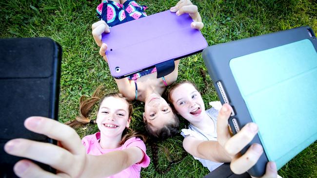 Evia, Claudia and Tiger use their tablets to research school projects, as well as for reading and maths apps. Picture: Nicole Cleary