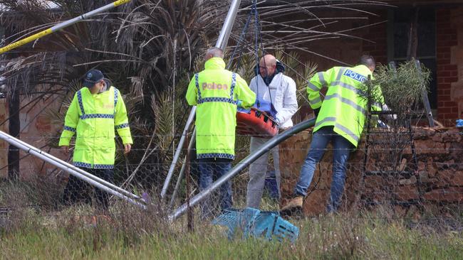 Police remove remains believed to be that of Robert Atkins from a water tank in the state’s Mid North on Thursday. Picture: Riley Walter