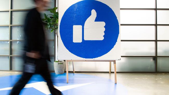 How many individuals like Facebook enough to use it? Above, a Facebook employee walks by a sign displaying the ‘like’ sign at Facebook's corporate headquarters campus in Menlo Park, California. Picture: AFP