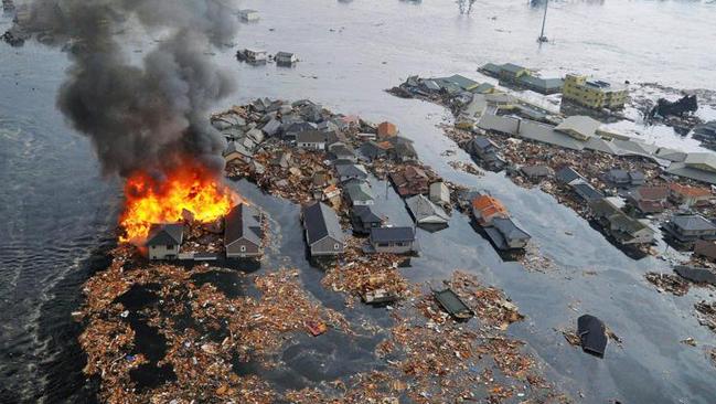 Houses swallowed by tsunami waves burn in Natori, Miyagi Prefecture (state) after Japan was struck by a strong earthquake off its northeastern coast Friday, March 11, 2011. (AP Photo/Kyodo News) MANDATORY CREDIT, NO LICENSING ALLOWED IN CHINA, HONG KONG, JAPAN, SOUTH KOREA AND FRANCE