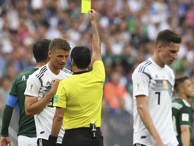 Faghani brandishes a yellow card to Germany’s Thomas Muller.