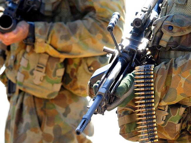 TOWNSVILLE, AUSTRALIA - SEPTEMBER 04:  A soldier from an infantry section carries his 5.56mm minimi machine gun  during an Army fire power demonstration at Range Control, High Range on September 4, 2009 in Townsville, Australia. The demonstration, especially of the high range weapons, is intended to demonstrate the level and effect of firepower available to the soldiers of 3rd Brigade should they be deployed on operations requiring such.  (Photo by Ian Hitchcock/Getty Images)