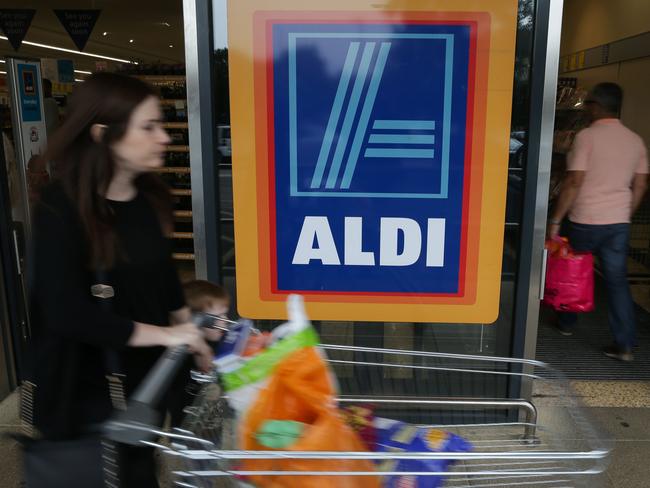 A woman pushes a shopping trolley in front of Aldi. Picture: AFP