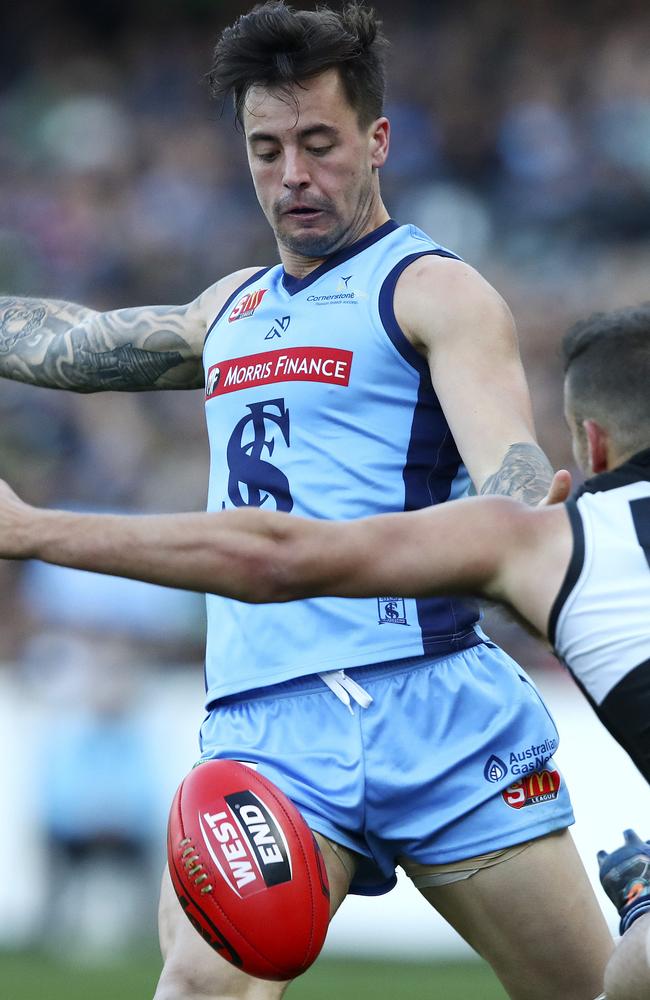 Sturt’s Jake Sutcliffe gets his kick away from Port’s Jimmy Toumpas. Picture: SARAH REED