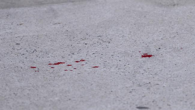 Drops of blood on the footpath at the scene. Picture: Nicki Connolly