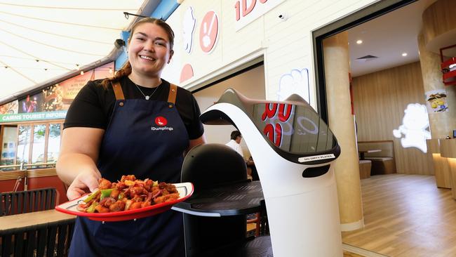 Megan Cairns serves up some sweet and sour pork delivered by Bella the robot at the new Impressive Dumplings restaurant. Picture: Brendan Radke