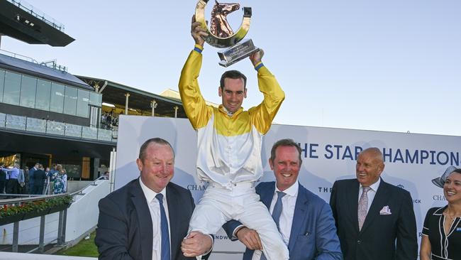 Co-trainers Wayne Hawkes (left) and Michael Hawkes lift jockey Tyler Schiller after Briasa won the TJ Smith Stakes at Randwick in April. Picture: Bradley Photos