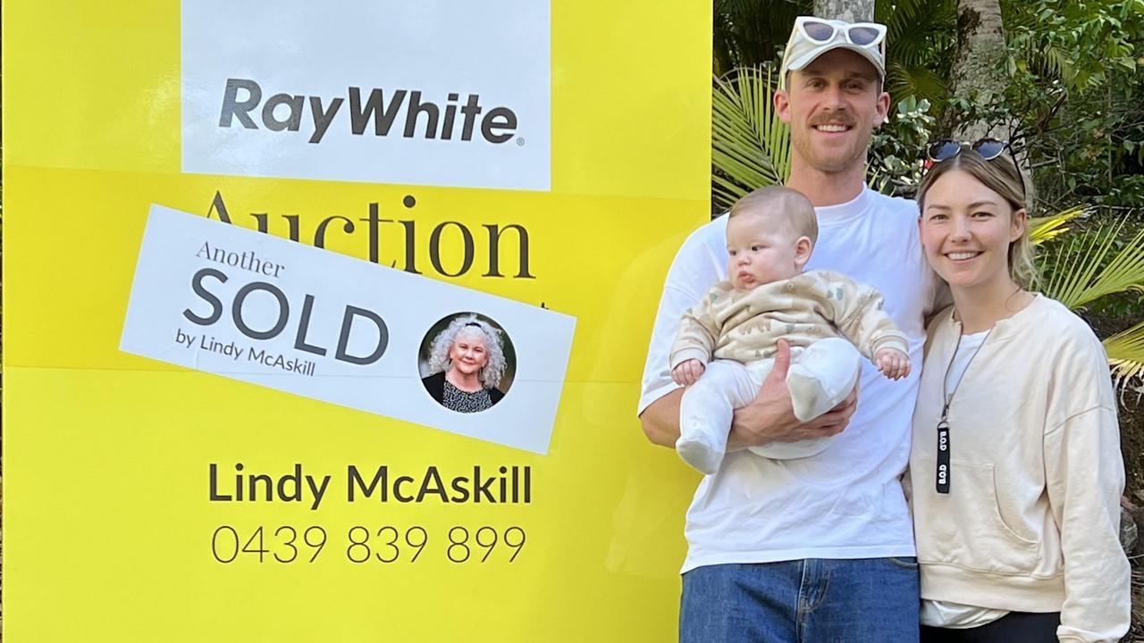 Jordie Hansen and Sam Frost with baby, Ted, pose for a photo after buying a Doonan home at auction. Image supplied by Ray White.