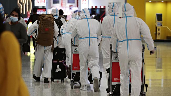 Travellers in full PPE arrive at Sydney International Airport this morning. Picture: Adam Yip