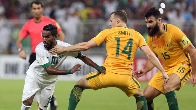 Saudi's Nawaf Alabid (L) dribbles past Australia's Brad Smith (C).