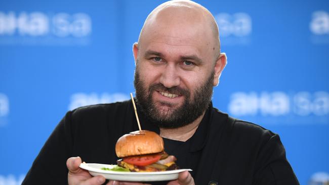 Patrick Spriggs from the Eyre Hotel holds his winning Smash Burger after winning the title "SA Best Pub Burger". Picture: Mark Brake.