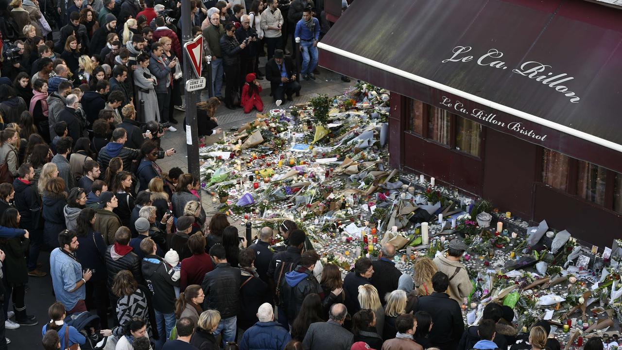 People gather at a makeshift memorial in front of "Le carillon" restaurant following the attacks.