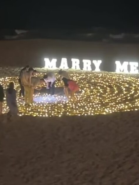 Zay and Sai sift through sand to locate the missing engagement ring.