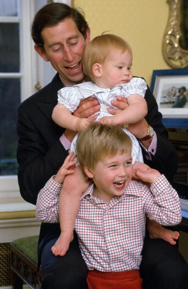 Prince Charles laughing with his sons as he lifts Prince Harry onto Prince William’s shoulders. Picture: Tim Graham