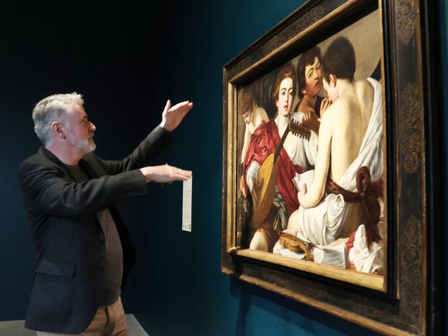 Michael Gallagher from The Metropolitan Museum of Art, New York, pictured with Caravaggio's 'The Musicians', who is overseeing the presentation of paintings in the European Masterpieces exhibition at QAGOMA. Picture Lachie Millard