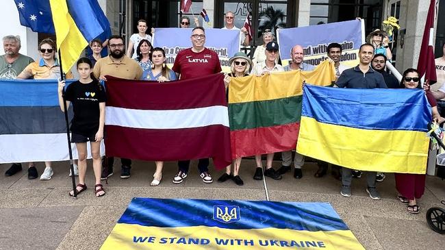 Members of the Latvian, Estonina, Lithuanian and Ukraine communities stand together in Darwin in front of Northern Territory Parliament House