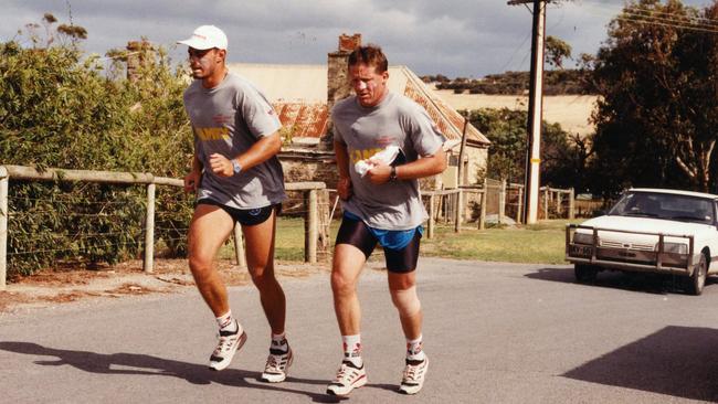 Paul Rouvray, left, and Chris McDermott running up hill during Adelaide Crows pre-season training camp at Wirrina Cove in 1995.