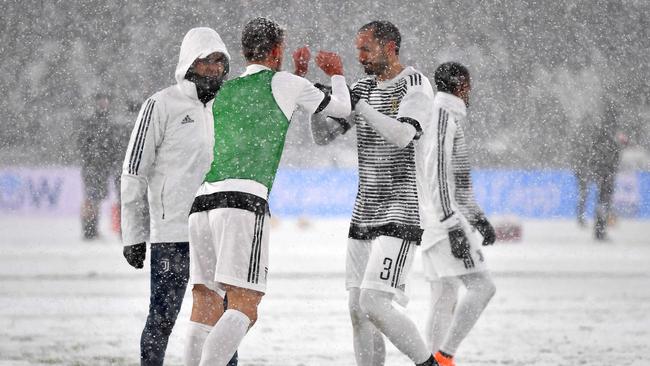 Juventus' players warm up under heavy snowfall before the postponed Italian Serie A football match