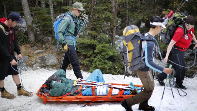 In this Sunday, May 3, 2015 photo, a skier with a leg injury is transported by sled down a 3-mile-long trail after getting hurt on Tuckerman Ravine on Mount Washington in New Hampshire. Some are drawn by the freaky weather on Mount Washington, the Northeast’s highest peak that was once home to the fastest wind speed ever recorded (231 mph) and is a virtual snow gun from October to May. Others relish the risks, including avalanches, falling ice and crevasses. Snow rangers remind even Tuckerman veterans that no two runs are alike in the unpredictable bowl. People get hurt here. (AP Photo/Robert F. Bukaty)